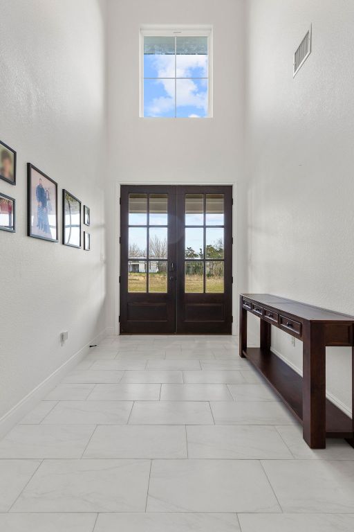 479 Brown Rd, Mcdade, TX 78650 - foyer with french doors, a towering ceiling, and baseboards