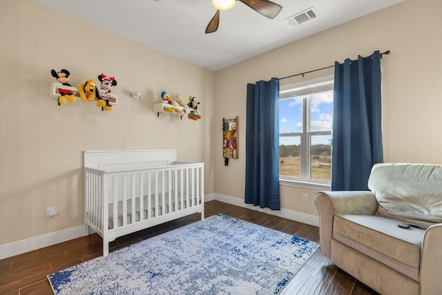 479 Brown Rd, Mcdade, TX 78650 - bedroom featuring wood finished floors, baseboards, a crib, and ceiling fan