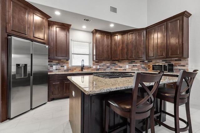 479 Brown Rd, Mcdade, TX 78650 - kitchen featuring appliances with stainless steel finishes, a sink, dark brown cabinets, a kitchen island, and recessed lighting