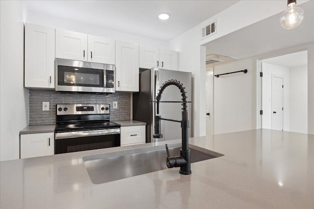 909 Reinli St Unit 231, Austin, TX 78751 - kitchen featuring appliances with stainless steel finishes, white cabinetry, decorative backsplash, recessed lighting, and a sink