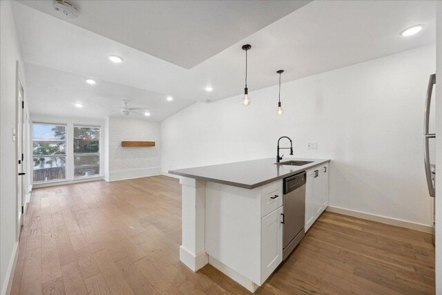 909 Reinli St Unit 231, Austin, TX 78751 - kitchen with stainless steel dishwasher, a ceiling fan, light wood finished floors, a peninsula, and white cabinets