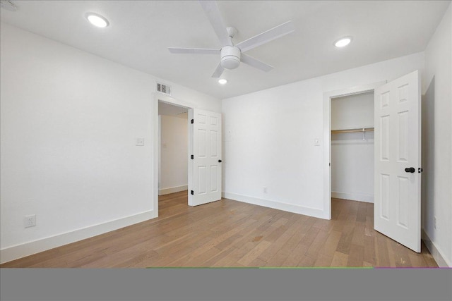 909 Reinli St Unit 231, Austin, TX 78751 - unfurnished bedroom with light wood-style floors, baseboards, a walk in closet, a closet, and recessed lighting