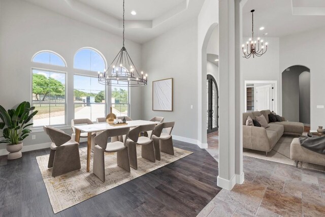 8295 Lime Creek Rd, Volente, TX 78641 - dining area featuring arched walkways, a chandelier, a high ceiling, baseboards, and dark wood finished floors