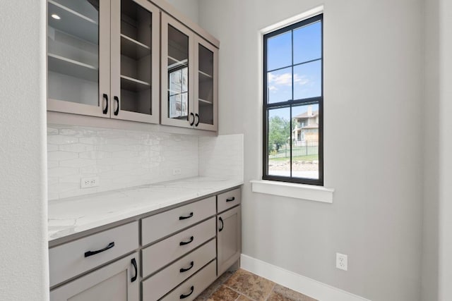 8295 Lime Creek Rd, Volente, TX 78641 - kitchen with backsplash, healthy amount of natural light, baseboards, and glass insert cabinets