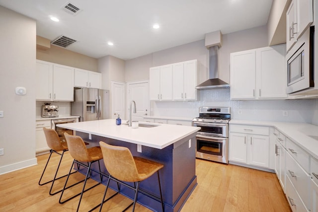 2520 Bluebonnet Ln Unit 41, Austin, TX 78704 - kitchen featuring stainless steel appliances, a sink, wall chimney range hood, a kitchen bar, and backsplash