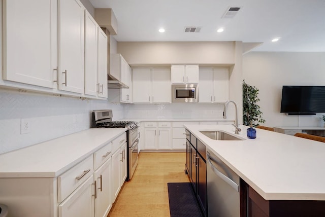 2520 Bluebonnet Ln Unit 41, Austin, TX 78704 - kitchen with appliances with stainless steel finishes, a sink, light countertops, white cabinetry, and recessed lighting