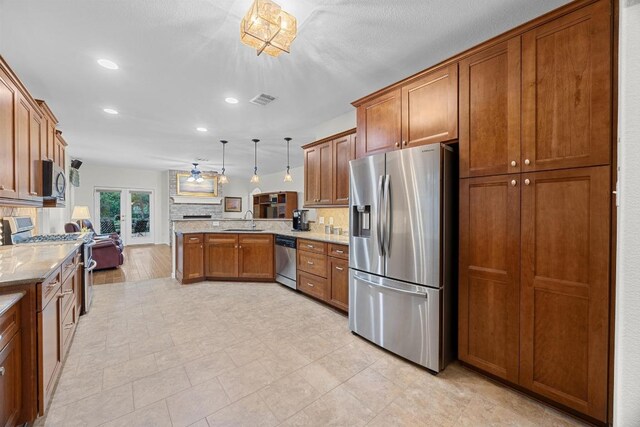 2518 Nightshade Dr, Cedar Park, TX 78613 - kitchen with appliances with stainless steel finishes, a sink, a peninsula, brown cabinetry, and recessed lighting