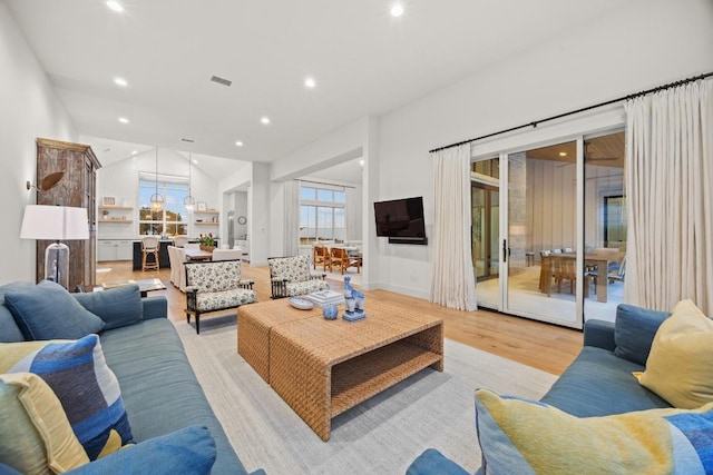 living room with light wood-style flooring, recessed lighting, and lofted ceiling