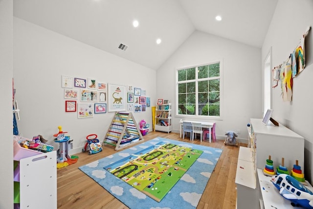 playroom with wood finished floors, high vaulted ceiling, recessed lighting, and baseboards