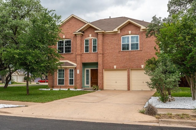 8610 Axis Dr, Austin, TX 78749 - view of front of home with concrete driveway, a front yard, an attached garage, and brick siding