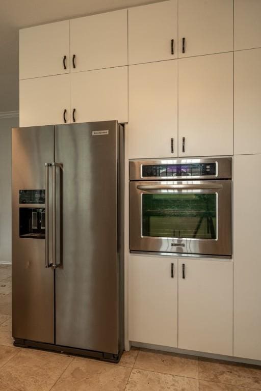 8610 Axis Dr, Austin, TX 78749 - kitchen featuring appliances with stainless steel finishes, white cabinets, and light tile patterned flooring