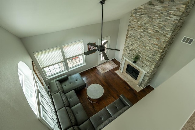 8610 Axis Dr, Austin, TX 78749 - living area featuring a ceiling fan, wood finished floors, a large fireplace, lofted ceiling, and baseboards
