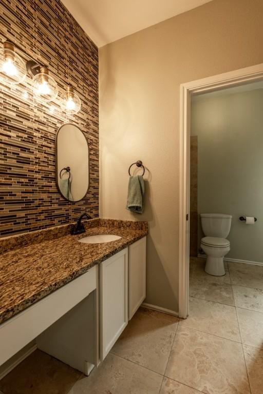 8610 Axis Dr, Austin, TX 78749 - bathroom with tile patterned floors, vanity, baseboards, and toilet