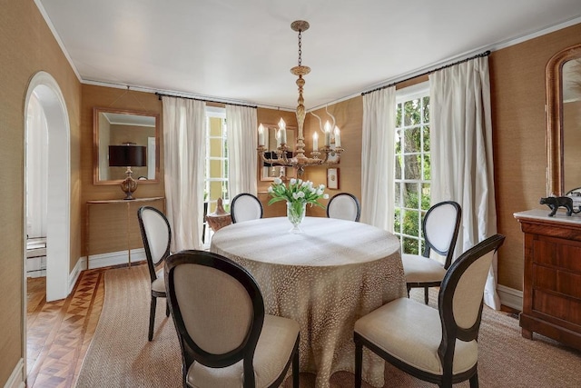 dining space featuring a chandelier, baseboards, and ornamental molding