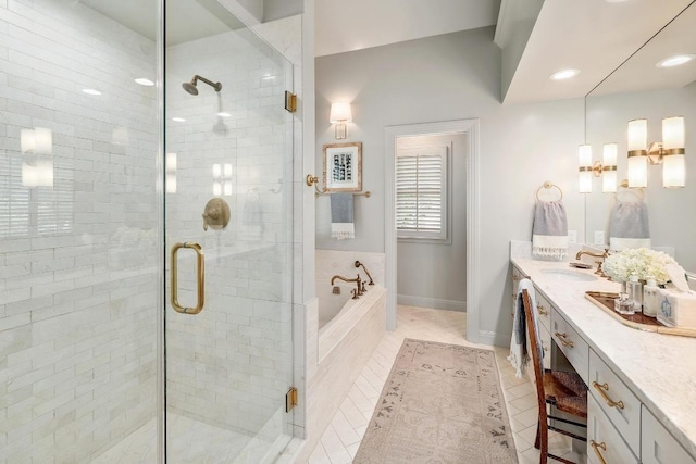 bathroom featuring a garden tub, vanity, and a stall shower