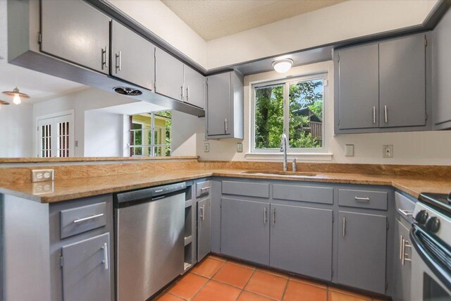 3508 Winfield Cv, Austin, TX 78704 - kitchen featuring stainless steel appliances, a sink, gray cabinetry, a peninsula, and light tile patterned floors