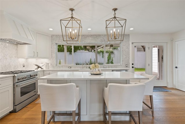 3115 Thousand Oaks Dr, Austin, TX 78746 - kitchen with high end stainless steel range, a chandelier, a kitchen breakfast bar, light countertops, and recessed lighting