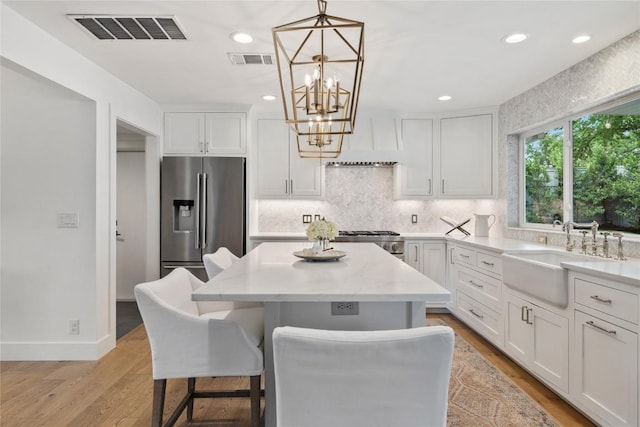 3115 Thousand Oaks Dr, Austin, TX 78746 - kitchen featuring a sink, stainless steel refrigerator with ice dispenser, range, white cabinetry, and backsplash