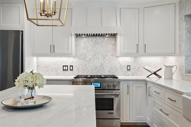 3115 Thousand Oaks Dr, Austin, TX 78746 - kitchen with appliances with stainless steel finishes, tasteful backsplash, a chandelier, light stone counters, and white cabinets
