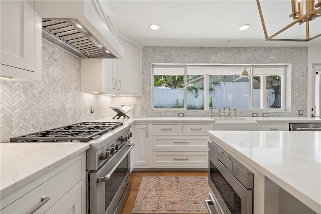 3115 Thousand Oaks Dr, Austin, TX 78746 - kitchen with stainless steel appliances, range hood, a sink, backsplash, and white cabinets