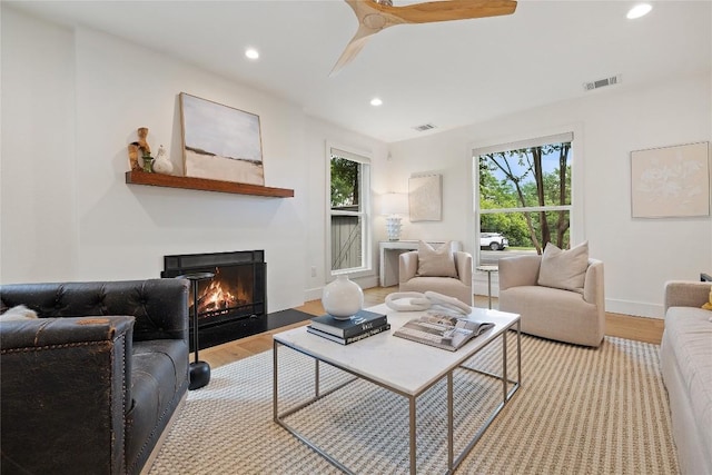 3115 Thousand Oaks Dr, Austin, TX 78746 - living area featuring wood finished floors, a warm lit fireplace, recessed lighting, baseboards, and a ceiling fan
