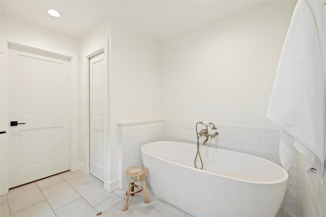 3115 Thousand Oaks Dr, Austin, TX 78746 - bathroom featuring a soaking tub, tile patterned flooring, tile walls, and recessed lighting