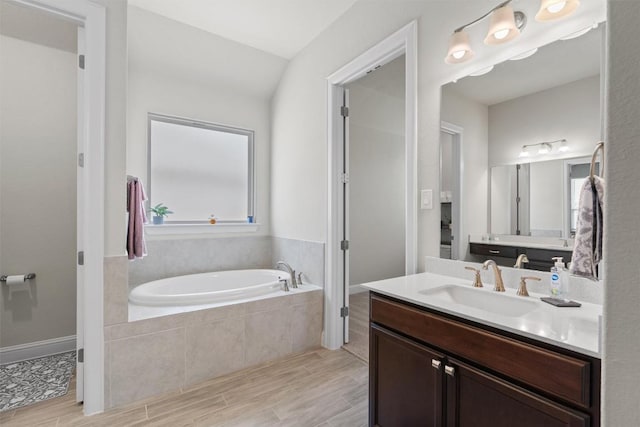 full bath featuring a garden tub, wood finished floors, and vanity