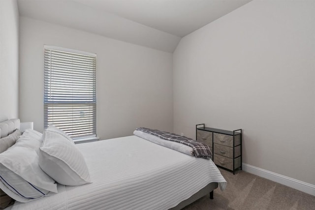carpeted bedroom with baseboards and vaulted ceiling