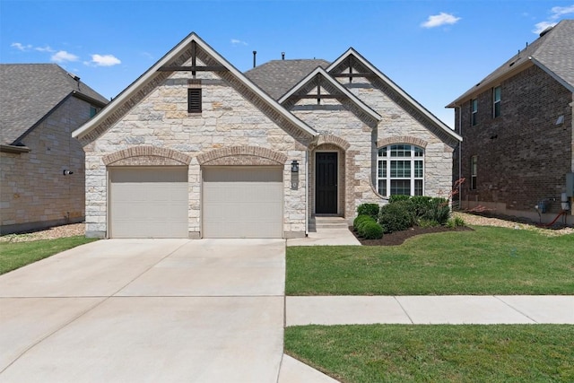 french provincial home featuring a garage, concrete driveway, stone siding, and a front lawn