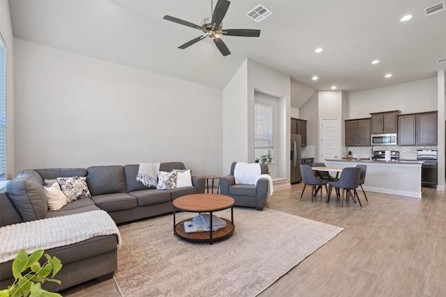 living room with light wood-type flooring, recessed lighting, and a ceiling fan
