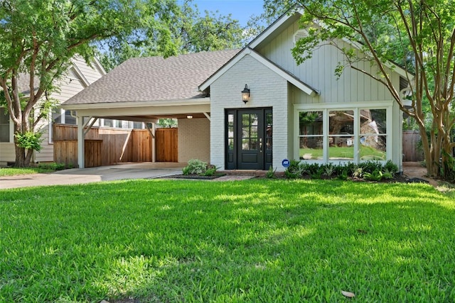 view of front of property featuring a shingled roof, brick siding, an attached carport, and driveway