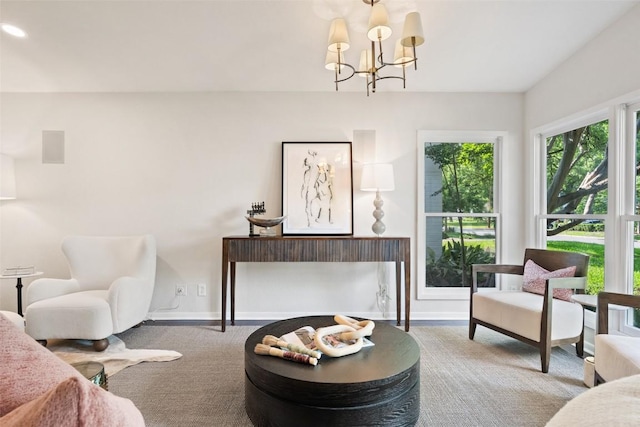 sitting room featuring a chandelier and baseboards