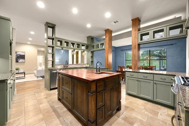 209 Ridge View Dr, Georgetown, TX 78628 - kitchen with a sink, stainless steel appliances, a kitchen island with sink, wooden counters, and green cabinetry
