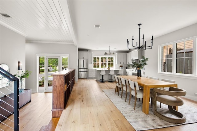 2625 Exposition Blvd, Austin, TX 78703 - dining area with a chandelier, light wood-style floors, and crown molding