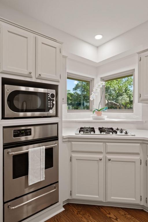 6304 John Chisum Ln, Austin, TX 78749 - kitchen featuring appliances with stainless steel finishes, a warming drawer, white cabinetry, light countertops, and dark wood-type flooring