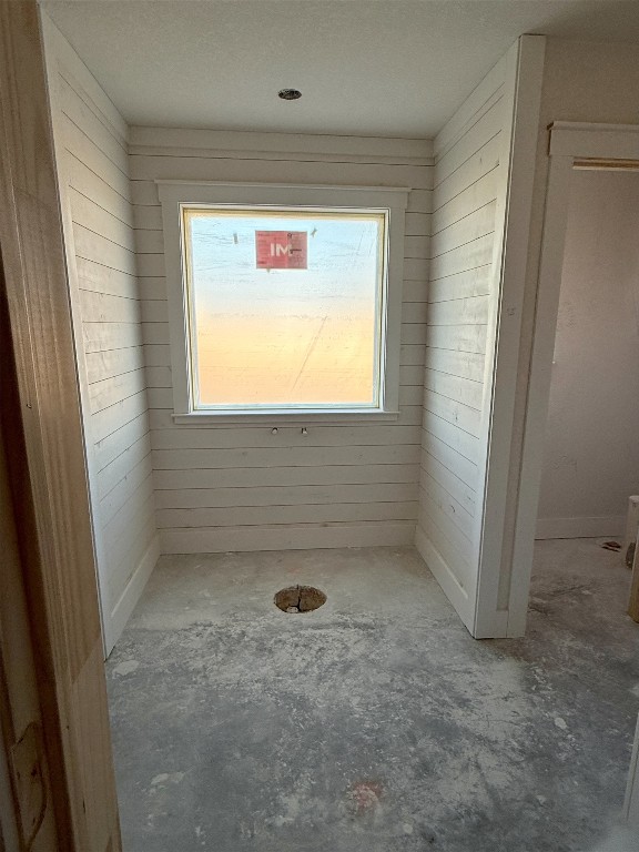 108 Aidan Ct, Burnet, TX 78611 - bathroom featuring unfinished concrete flooring, wooden walls, and healthy amount of natural light
