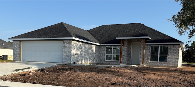 108 Aidan Ct, Burnet, TX 78611 - view of front of home with brick siding, an attached garage, concrete driveway, and a shingled roof