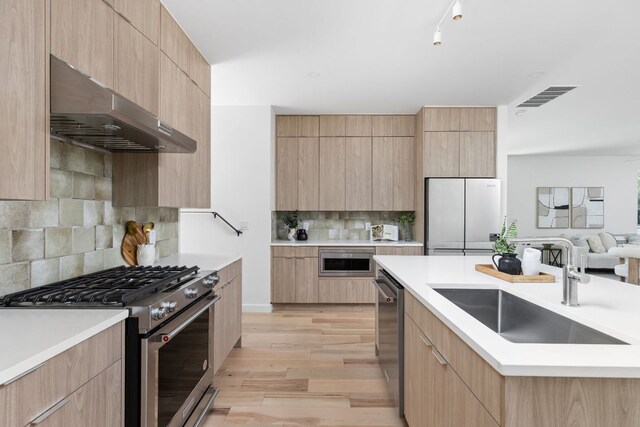 2903 Breeze Ter Unit 1, Austin, TX 78722 - kitchen featuring appliances with stainless steel finishes, ventilation hood, modern cabinets, and light brown cabinets