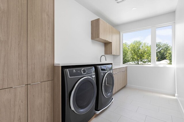 2903 Breeze Ter Unit 1, Austin, TX 78722 - laundry room with cabinet space, washer and dryer, light tile patterned floors, and baseboards