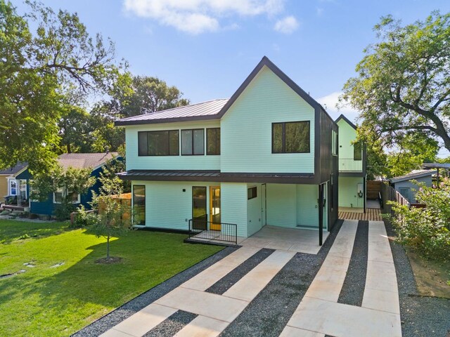 2903 Breeze Ter Unit 1, Austin, TX 78722 - rear view of house with concrete driveway, metal roof, a yard, and a standing seam roof