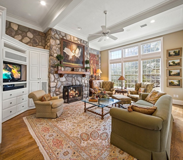 124 Florentine, Horseshoe Bay, TX 78657 - living room with wood finished floors, crown molding, a ceiling fan, a fireplace, and beamed ceiling