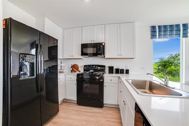 1006 Antelope Trl, Temple, TX 76504 - kitchen featuring black appliances, a sink, light countertops, light wood-style flooring, and white cabinetry