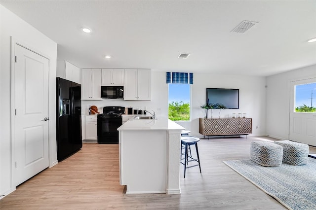 1006 Antelope Trl, Temple, TX 76504 - kitchen featuring black appliances, a sink, light wood-type flooring, white cabinetry, and recessed lighting