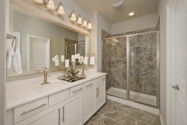 full bathroom featuring a stall shower, double vanity, and recessed lighting