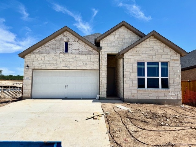 999 N Roger Hanks Pkwy, Dripping Springs, TX 78620 - french country home with concrete driveway, a garage, and stone siding