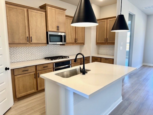 999 N Roger Hanks Pkwy, Dripping Springs, TX 78620 - kitchen with stainless steel microwave, oven, a sink, light wood-style flooring, and backsplash