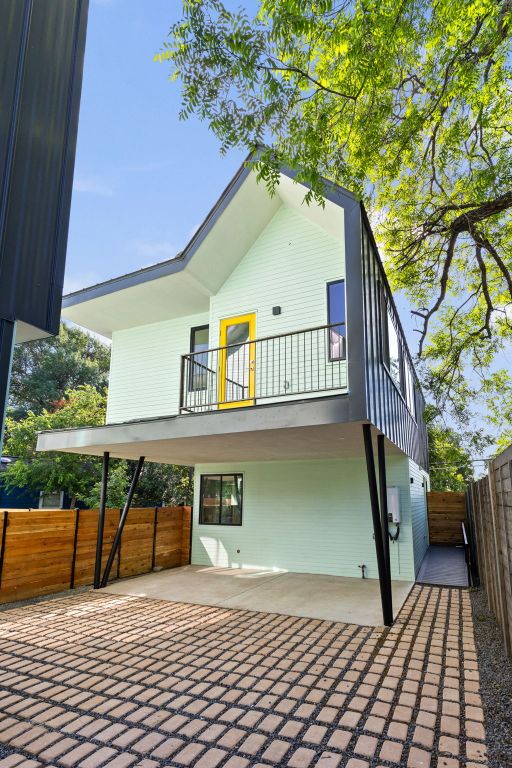 back of property featuring a balcony, fence, and a patio
