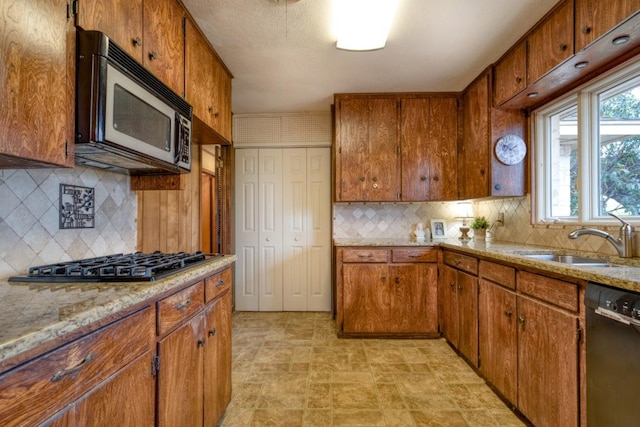 508 Lee St N, Round Rock, TX 78664 - kitchen featuring gas stovetop, black dishwasher, a sink, and tasteful backsplash