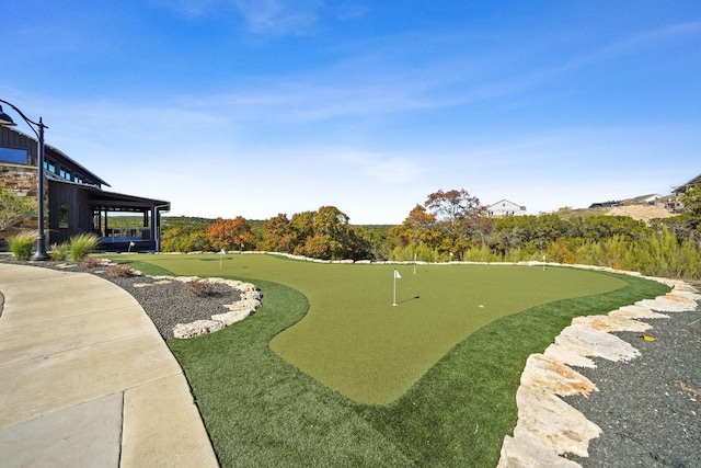 view of property's community featuring an area to practice putting