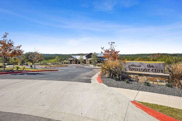 view of asphalt road featuring curbs and sidewalks